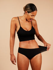 woman wearing one size stretchy period pants showing how much they can stretch