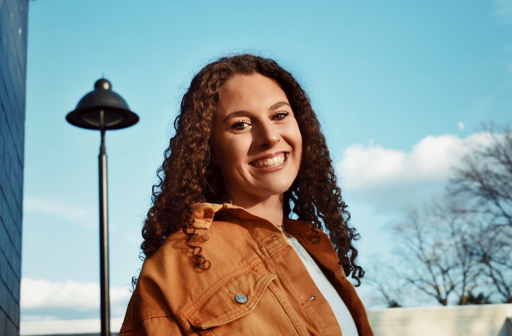 A young teen girl smiling at the camera, representing confidence and readiness for her first period.